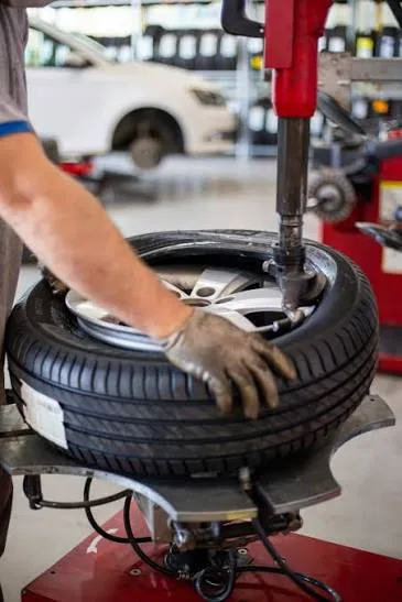 Technician mounting a tire on a wheel changer