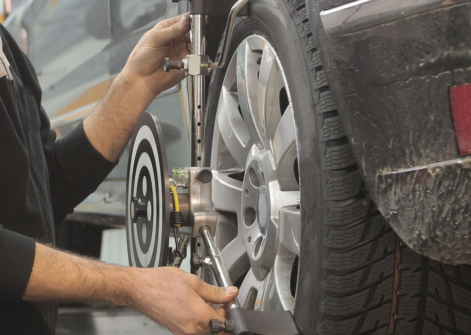 Alignment clamp being fitted to a car wheel during a wheel alignment